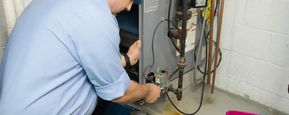 Furnace repair technician inspecting and servicing a home heating system in Scottsdale, AZ