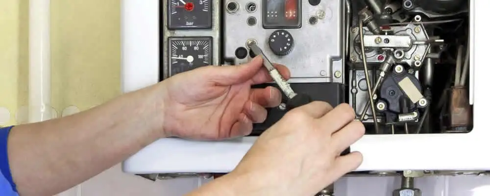Heating repair technician adjusting boiler controls and components in Scottsdale, AZ