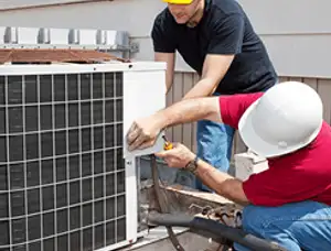 HVAC technicians repairing an outdoor AC unit on a rooftop in Scottsdale, AZ