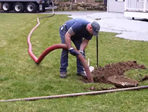 Septic pumping technician servicing a residential septic tank with a vacuum hose in Scottsdale, AZ