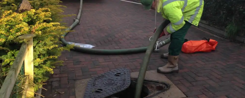 Septic tank cleaning technician servicing a septic tank with a vacuum hose in Scottsdale, AZ