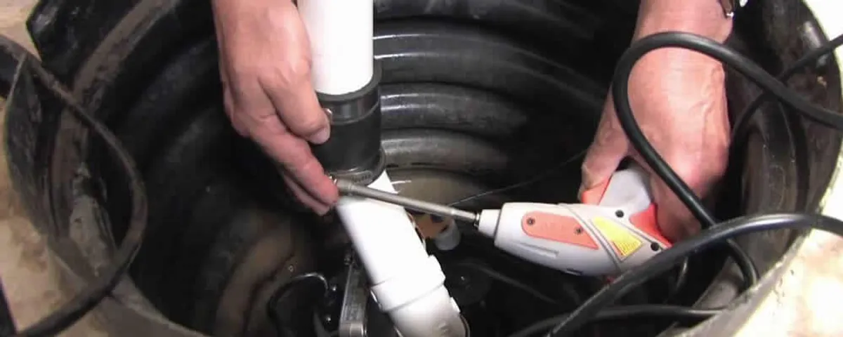 Sump pump installation technician connecting PVC discharge piping in Scottsdale, AZ