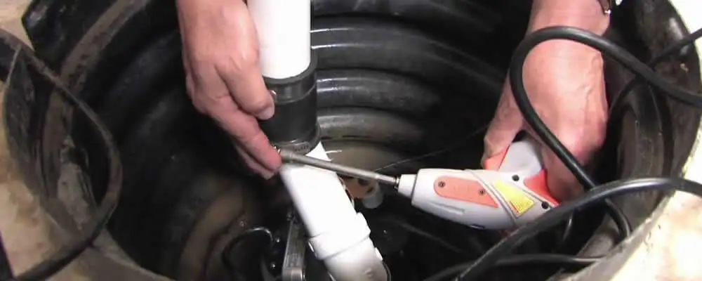 Sump pump installation technician connecting PVC discharge piping in Scottsdale, AZ