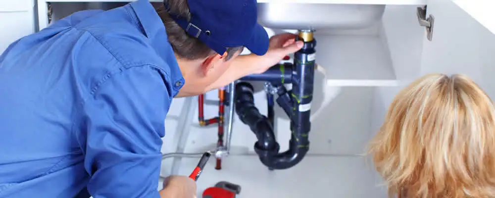 Plumber repairing under-sink drain pipes and fittings in Scottsdale, AZ